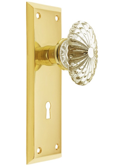 New York Style Door Set with Oval Fluted Crystal Glass Knobs with Keyhole in Unlacquered Brass.